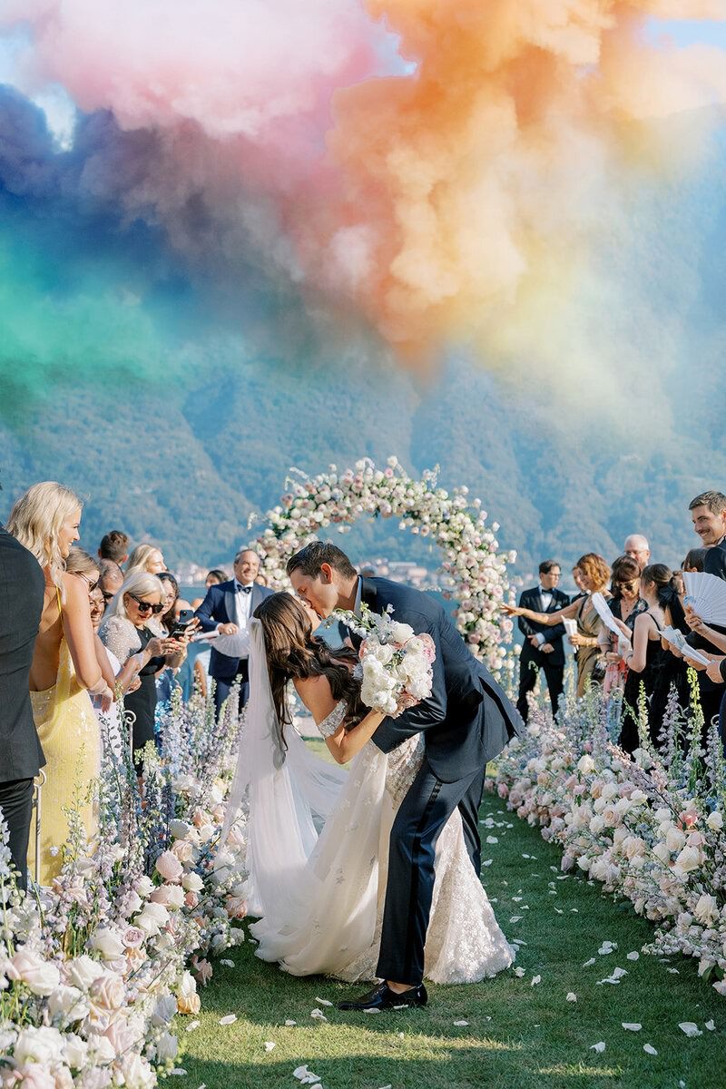 Newlyweds celebrate with colorful smoke during the end of their ceremony at Villa Balbiano in Lake Como.